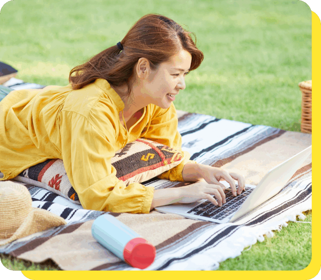 Woman smiling while using a laptop, planning her finances with a goal savings calculator.