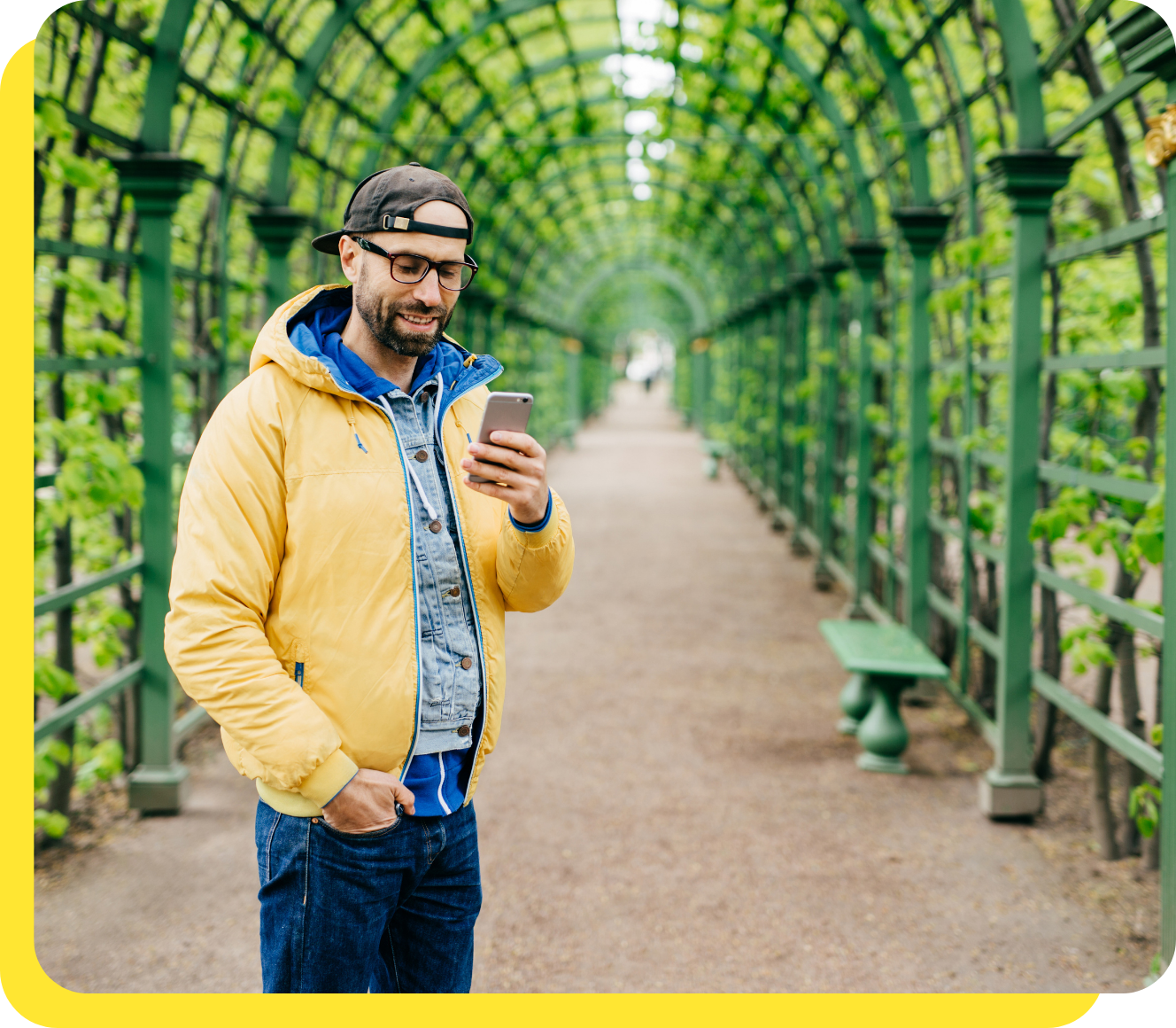 Man smiling while using his phone, managing his payroll savings with ease.