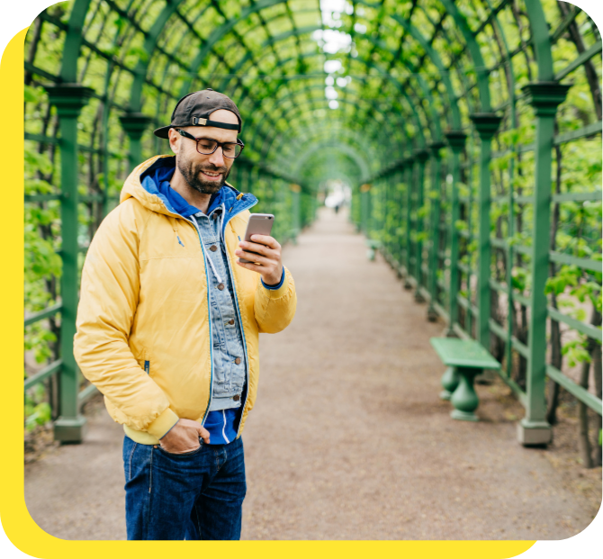 Man smiling while using his phone, managing his payroll savings with ease.