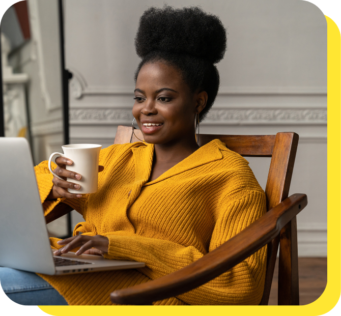 Woman smiling warmly whilst holding a coffee mug and reading about Serve and Protect Credit Union on her laptop, discovering how payroll deduction can help manage her finances effortlessly.