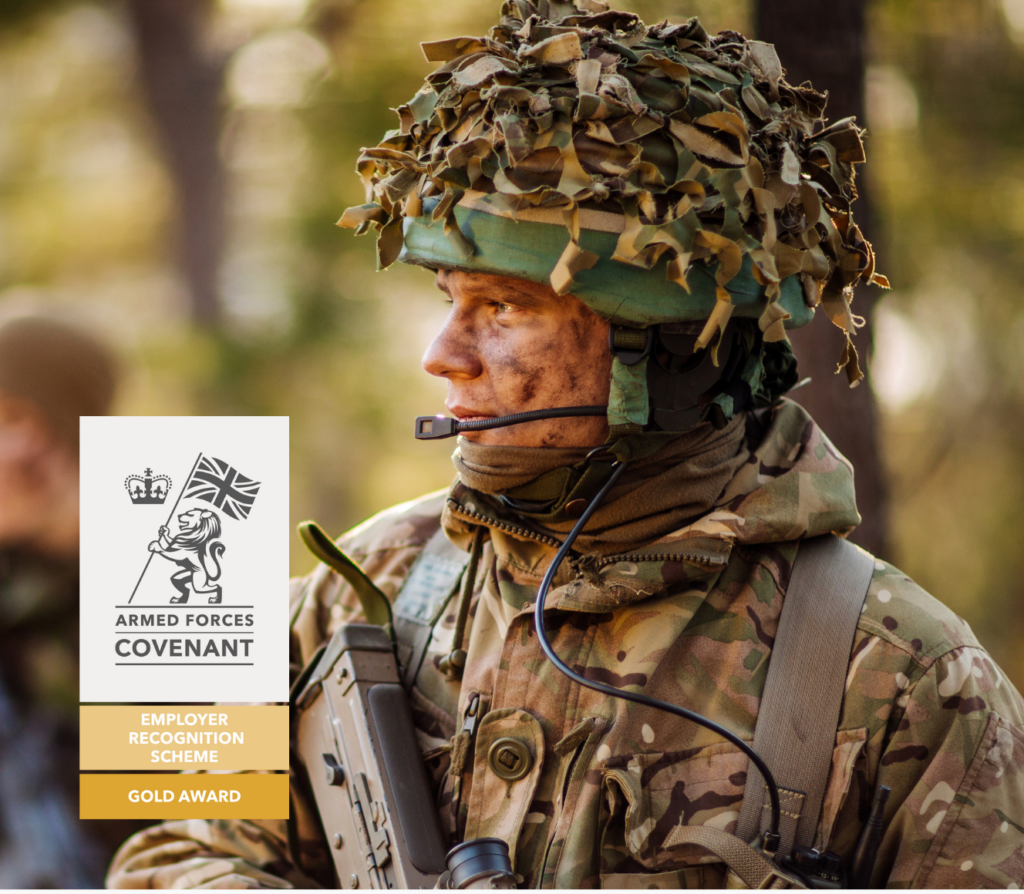 A proud soldier in uniform standing confidently with the Armed Forces Covenant Gold Award logo, representing the company's commitment as an armed forces-friendly employer.